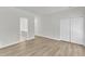 Bright bedroom featuring closet and ensuite bathroom with wood-look floors and freshly painted white walls at 1202 Kendall Dr, Durham, NC 27703
