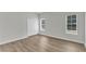 Bedroom with wood-look floors, a double-door closet, and two bright windows at 1202 Kendall Dr, Durham, NC 27703