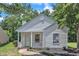 Charming home featuring a covered entryway, light siding, and manicured landscaping at 1202 Kendall Dr, Durham, NC 27703
