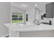 Well-lit kitchen with white quartz countertops, stainless steel faucet, and a view of the backyard at 1202 Kendall Dr, Durham, NC 27703