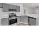Functional kitchen with stainless steel appliances, gray cabinetry, quartz countertops, and ample counter space at 1202 Kendall Dr, Durham, NC 27703