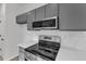 Contemporary kitchen featuring stainless steel appliances, gray cabinets and white subway tile backsplash at 1202 Kendall Dr, Durham, NC 27703