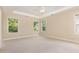Spacious main bedroom with tray ceiling, neutral carpet, and bright windows overlooking trees at 1304 Barnford Mill Rd, Wake Forest, NC 27587