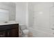 Well-lit bathroom featuring a dark wood vanity with sink, toilet, and a tub with a shower at 140 Token House Rd, Durham, NC 27703