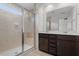 Bathroom with a large glass-enclosed shower, double vanity with dark wood cabinets, and a large mirror at 140 Token House Rd, Durham, NC 27703