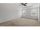 Spacious bedroom featuring tray ceilings, a ceiling fan, and bright natural light from two windows at 140 Token House Rd, Durham, NC 27703