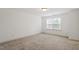 Bright bedroom with neutral carpet, large window providing ample natural light, and clean, white walls at 140 Token House Rd, Durham, NC 27703