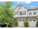 Inviting townhome showcasing stone accents, two-car garage, and lush landscaping at 140 Token House Rd, Durham, NC 27703