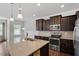 Open concept kitchen boasts stainless steel appliances and a granite island at 140 Token House Rd, Durham, NC 27703