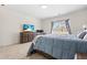 Bright bedroom features a TV, neutral carpet, and a window with natural light at 1400 Manley Ct, Fuquay Varina, NC 27526