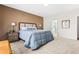 Well-lit bedroom features a cozy bed, neutral carpet, and a view to a connecting bathroom at 1400 Manley Ct, Fuquay Varina, NC 27526