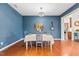 Dining room with hardwood floors, blue walls, and a table ready for a cozy meal at 1400 Manley Ct, Fuquay Varina, NC 27526