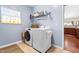Laundry room with washer, dryer, storage shelf, and natural light at 1400 Manley Ct, Fuquay Varina, NC 27526