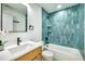 Bathroom showcasing sleek vanity, bathtub with a unique blue tiled shower at 1410 Joe Louis Ave, Raleigh, NC 27610