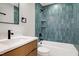 Bathroom showcasing sleek vanity, bathtub with a unique blue tiled shower at 1410 Joe Louis Ave, Raleigh, NC 27610