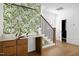 Stylish entryway featuring a wet bar with unique wallpaper and a staircase with black iron railings at 1410 Joe Louis Ave, Raleigh, NC 27610