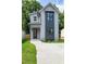 Charming two-story home featuring modern architectural design with a concrete driveway and well-maintained lawn at 1410 Joe Louis Ave, Raleigh, NC 27610