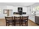 Open kitchen featuring white cabinets, quartz countertops, an island with seating, and black tile backsplash at 1410 Joe Louis Ave, Raleigh, NC 27610