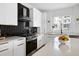 Modern kitchen with stainless steel appliances, white cabinets, black tiled backsplash, and a quartz countertop island at 1410 Joe Louis Ave, Raleigh, NC 27610