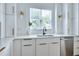 Bright kitchen with white cabinets, quartz countertops, stainless steel appliances, and a window view at 1410 Joe Louis Ave, Raleigh, NC 27610