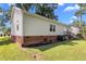 The vinyl-sided home includes a door leading to stairs, backyard with partial landscaping and grass at 1442 Morningside Dr, Burlington, NC 27217