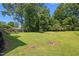 Expansive backyard featuring lush green lawn and mature trees perfect for outdoor activities and relaxation at 1442 Morningside Dr, Burlington, NC 27217