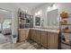 Bathroom with double sink vanity, wood cabinets, drawers, storage shelves, and laminate flooring at 1442 Morningside Dr, Burlington, NC 27217