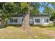 Single-story home with vinyl siding and dark shutters, shaded by a large tree in the front yard at 1442 Morningside Dr, Burlington, NC 27217