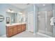 Bathroom with double vanity, mirror, and glass-enclosed shower stall at 1601 Bellenden Dr, Durham, NC 27713