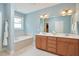 Bright bathroom featuring double vanity, soaking tub, and a large mirror at 1601 Bellenden Dr, Durham, NC 27713