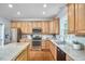 Well-lit kitchen boasts stainless steel appliances, wood cabinets, granite countertops, and a functional layout at 1601 Bellenden Dr, Durham, NC 27713