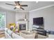 Cozy living room featuring a fireplace, ceiling fan, plush sofa, and a large television at 1601 Bellenden Dr, Durham, NC 27713