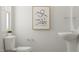 Bathroom featuring pedestal sink, modern art, and toilet with a small plant at 164 Paramount Dr, Smithfield, NC 27577