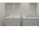 Functional laundry area with modern white washer and dryer, wire shelving, and neatly stacked towels at 164 Paramount Dr, Smithfield, NC 27577