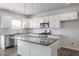 A modern kitchen with white cabinets, granite countertops, stainless steel appliances, and stylish pendant lighting at 167 Young Farm Dr, Lillington, NC 27546