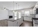 Open kitchen with granite island, stainless appliances, white cabinets, and view of the living area and fireplace at 167 Young Farm Dr, Lillington, NC 27546