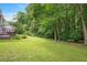 Sprawling green backyard with mature trees and a view of the back deck at 2008 Corberrie Ln, Raleigh, NC 27613