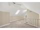 Bright bonus room features neutral carpet, fan, and stairs with white railings at 2008 Corberrie Ln, Raleigh, NC 27613