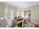 Dining room with modern chandelier, large windows, and view of staircase at 2008 Corberrie Ln, Raleigh, NC 27613