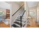 Elegant staircase with black and white risers and hardwood floors at 2008 Corberrie Ln, Raleigh, NC 27613