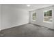 A sunlit bedroom features neutral colored walls, carpet floors and large windows at 2021 W Front St, Burlington, NC 27215