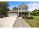 Charming two-story home featuring a brick and siding facade, attached garage, and a well-maintained front yard at 2021 W Front St, Burlington, NC 27215