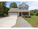 Charming two-story home featuring a brick and siding facade, attached garage, and a well-maintained front yard at 2021 W Front St, Burlington, NC 27215