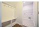 Functional mud room with a built-in bench and storage leading to the laundry room at 21 Abingdon Farms Dr, Selma, NC 27576