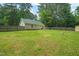 Open backyard featuring a fenced perimeter, lush green lawn, and exterior view of the home's rear at 2116 Sterling Creek Ln, Franklinton, NC 27525
