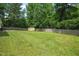Spacious backyard with lush green grass, storage shed, and a wooden fence providing privacy at 2116 Sterling Creek Ln, Franklinton, NC 27525