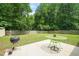 Large backyard with a patio featuring a grill and outdoor furniture, surrounded by mature trees at 2116 Sterling Creek Ln, Franklinton, NC 27525