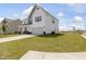 Two-story home with white siding, stone accents, covered porch, an attached two-car garage, and landscaped front yard at 218 Faith Avenue, Sanford, NC 27330