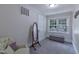 Bright bedroom with a patterned chair, large mirror, and a window view at 219 E Nash St, Spring Hope, NC 27882