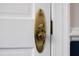Close up on a bright brass doorknob with an oval backplate on a white door with trim at 219 E Nash St, Spring Hope, NC 27882